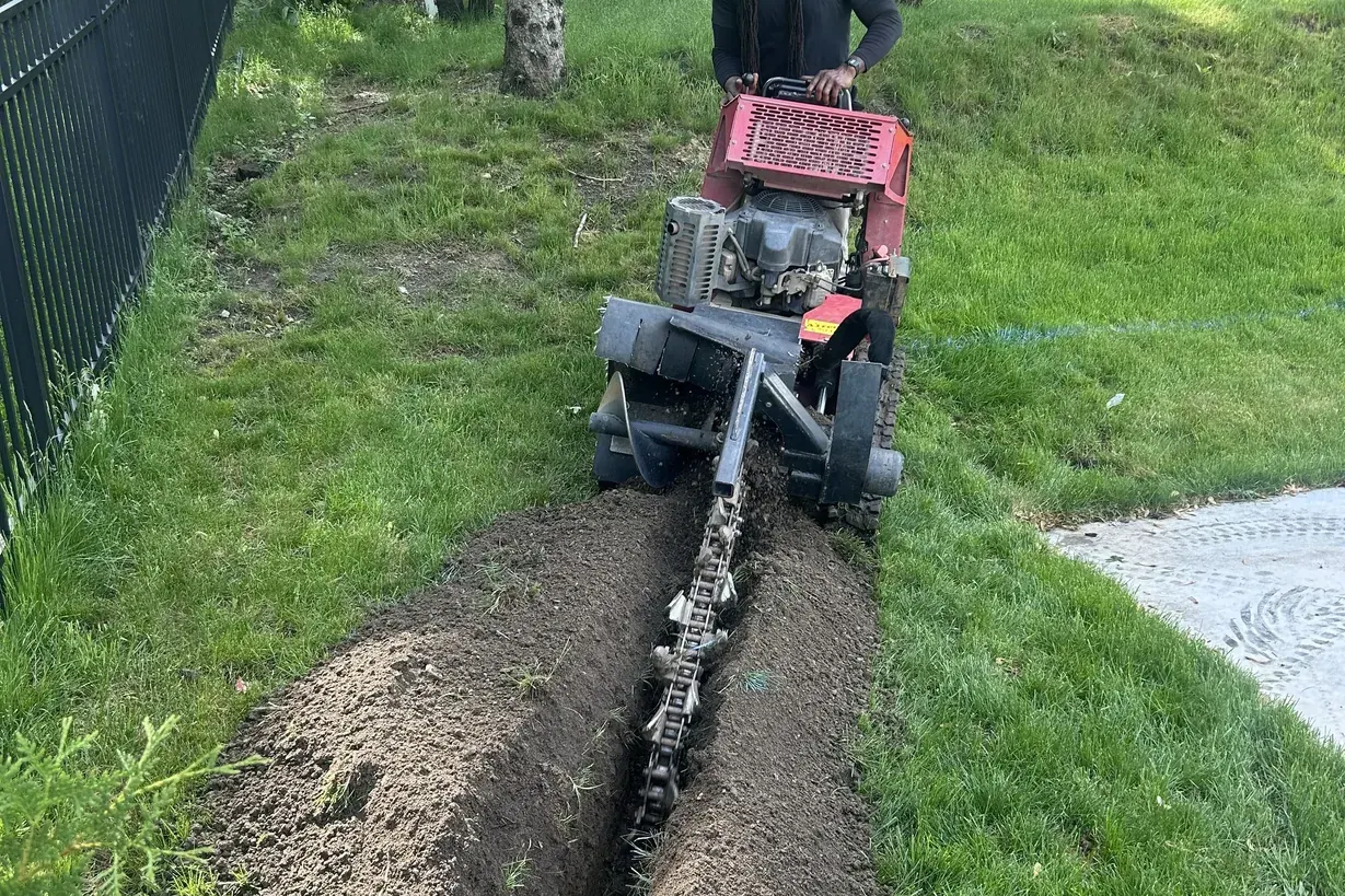 Walk-behind trencher cutting a trench for a French drain