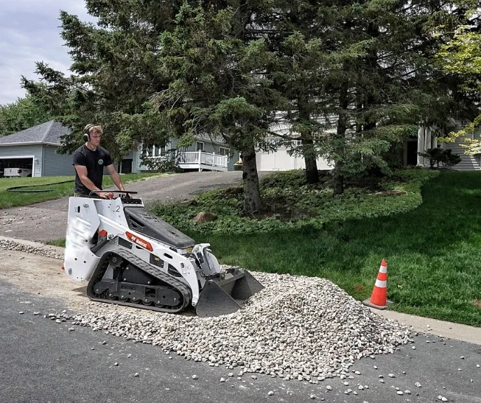 Professional landscapers laying commercial weed barrier and rock