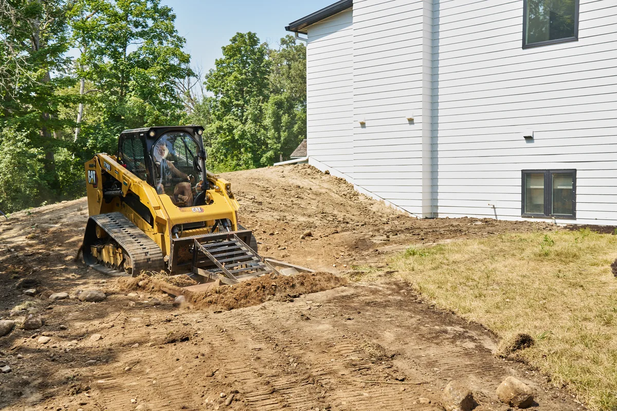 Compact track loader fine grading a yard in Shorewood